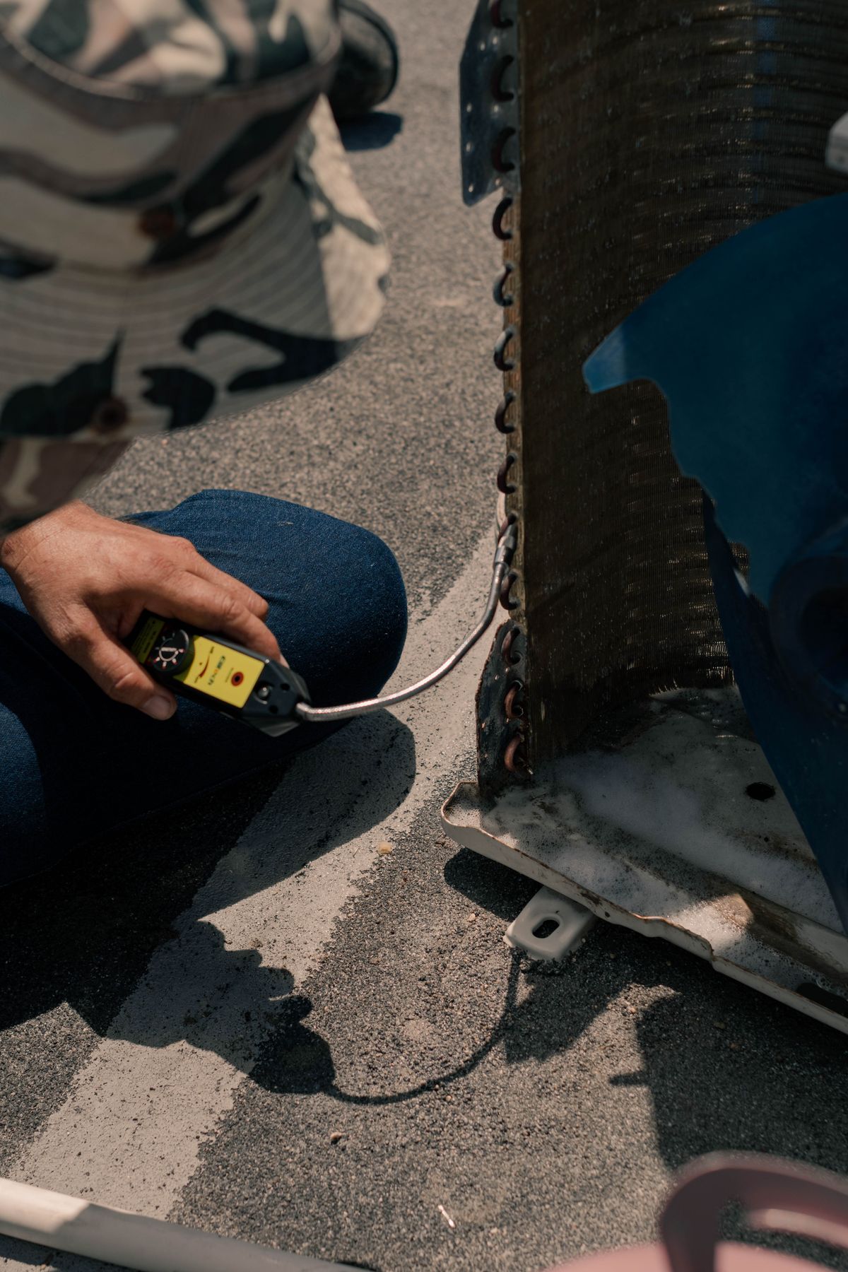 Close-up of a technician working on an air conditioning unit on a sunny day